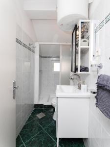 een witte badkamer met een wastafel en een toilet bij Apartments Roda in Supetar