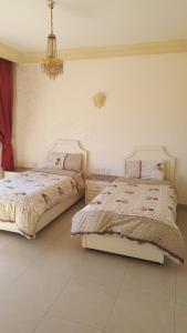 a bedroom with two beds and a chandelier at Al Khaleej Hotel Apartments in Amman +25 photos