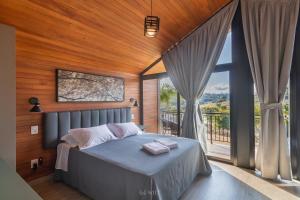 a bedroom with a bed and a large window at CABANAS LE VIGNE in Pinto Bandeira +61 photos