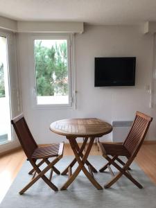 a table and two chairs in a room with a television at Appartement T2 Les papillons in Arcachon