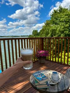 a person holding a glass of milk on a deck at Agroturystyka Widokówka Nielisz in Nielisz