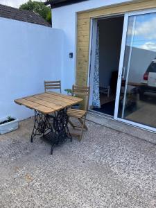 a wooden table and two chairs on a patio at The Snug self contained apartment in Killyleagh +12 photos