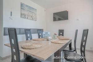 mesa de comedor de madera con sillas y TV en Dom 306 dom na wyłączność dla 6 osób z parkingiem, ogrodem i grillem, en Jastrzębia Góra
