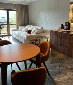 Una sala de estar con un sofá, una mesa y sillas. en Green Park Resort APARTAMENT B9 Basen, Sauna, Jacuzzi, Siłownia, Widok, en Szklarska Poręba