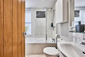 ein Badezimmer mit Badewanne, Toilette und Waschbecken in der Unterkunft Princess Green 4 - Portrush by the Sea in Portrush + 42 Fotos