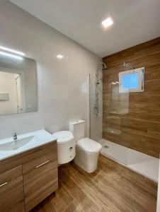 Un baño con inodoro, lavabo y ducha. en Atico con aire acondicionado y terraza, en Benicarló