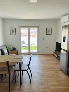 Una sala de estar con una mesa y un refrigerador. en Atico con aire acondicionado y terraza, en Benicarló