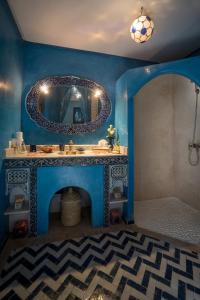 a blue bathroom with a sink and a mirror at Riad Dar Attika in Marrakesh