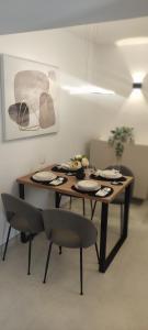 a table in a room with chairs and a table with plates at Apartman AMELIE A4 in Pula