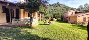 a house with a yard with two chairs in it at Bouganville in Costa Rei