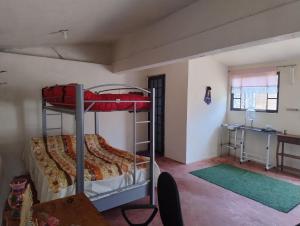 a bedroom with two bunk beds and a desk at Rancho Tlalinantli in San Miguel Ajusco