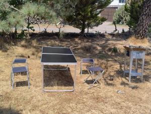a ping pong table and two stools and a table and chairs at Rancho Tlalinantli in San Miguel Ajusco