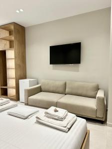 a living room with a couch and a flat screen tv at O'Det Luxury Rooms & Apartments in Sarandë