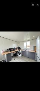 a large white kitchen with a table and a stove at La Maison du haut! in Sainte-Rose