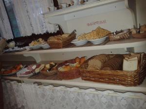 a shelf filled with baskets of bread and other foods at Pousada Gardenia Guest House in Gramado +37 photos
