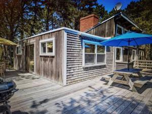 a small house with a picnic table and an umbrella at Nature Lover's Nest in Wellfleet