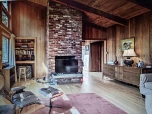 a living room with a fireplace and a brick wall at Nature Lover's Nest in Wellfleet