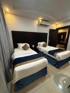a hotel room with two beds in a room at Ramis Serviced Apartments in Buraydah +58 photos
