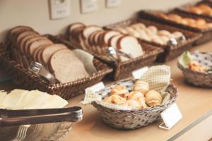 a table topped with baskets of bread and pastries at Class Hotel Alfenas in Alfenas