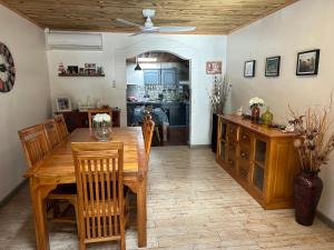 a kitchen and dining room with a wooden table and chairs at Maison de vacances à Bras-Panon in Bras-Panon
