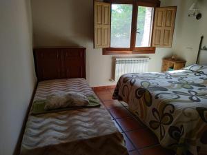 una camera da letto con due letti e una finestra di La casita de Duratón a Duratón