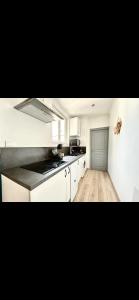 a kitchen with white cabinets and a counter top at Glycine in Orléans