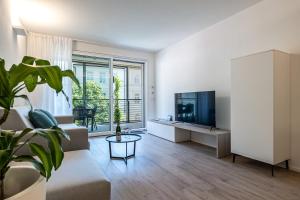 a living room with a couch and a tv at Lisa Loft & Suite in Arco