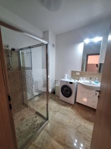 a bathroom with a shower and a washing machine at AquaTherm Felix in Sînmartin