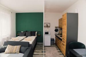 Una sala de estar con un sofá y una pared verde. en Apartment Vela, en Tuzla