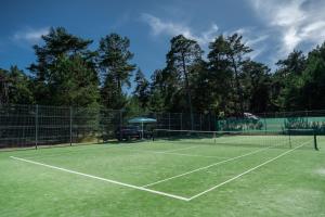 a tennis court with a net on top of it at Hotel Palanga Camping in Palanga