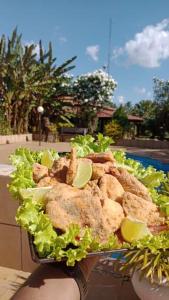 un piatto di cibo con lattuga e fette di lime di Clube de pesca e pousada boa sorte a Itauçu