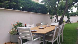 ein Holztisch und Stühle in einem Hof in der Unterkunft Maison en rez-de chaussée près du centre ville d'Arles in Arles