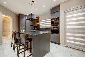 a kitchen with a large island with bar stools at Premier Seafront Living: Ultra-Luxury in Sliema in Sliema