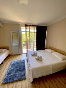 a bedroom with a large bed with two towels on it at Guest House Kobuleti on Aghmashenebeli in K'obulet'i