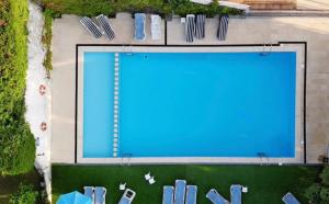 an overhead view of a swimming pool with chairs around it at Hotel Olimpo in Isla