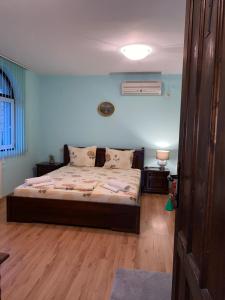 a bedroom with a bed with blue walls and wooden floors at Guest House Debar in Arbanasi +36 photos