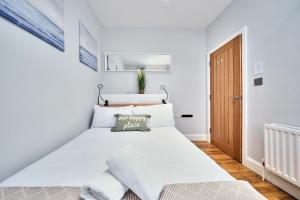 ein weißes Schlafzimmer mit einem großen weißen Bett. in der Unterkunft Princess Green 1 - Portrush by the Sea in Portrush