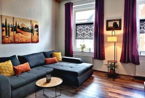 a living room with a blue couch and a table at Art ANTON - Stilvolle Wohnung mit Balkon, zentrumsnah in Plauen