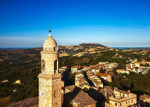 a tower with a clock on top of a city at La torre tra terra e cielo in Petritoli