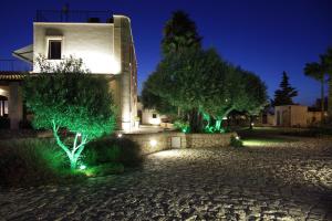a house with green lighting in front of a building at Casal Sikelio in Cassibile
