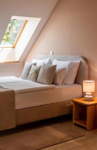 ein Bett mit weißen Kissen in einem Zimmer mit Fenster in der Unterkunft Aminess Kadoor Hotel in Karlovac