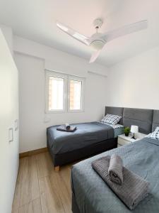 a bedroom with two beds and a ceiling fan at SoleOle in Playa de Gandia