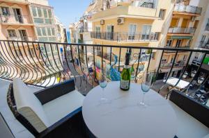 une table avec deux verres de vin sur un balcon dans l'établissement OASIS - PALM Old Town, à Benidorm