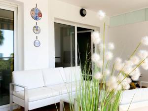 ein Wohnzimmer mit einer weißen Couch und einer Pflanze in der Unterkunft Beachside apartment Mi Capricho Portal 7 in Sitio de Calahonda