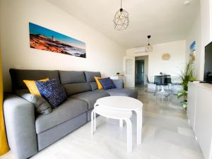 ein Wohnzimmer mit Sofa und Tisch in der Unterkunft Beachside apartment Mi Capricho Portal 7 in Sitio de Calahonda