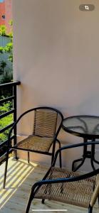 two tables and a chair on a balcony at Guest House Kobuleti on Aghmashenebeli in K'obulet'i