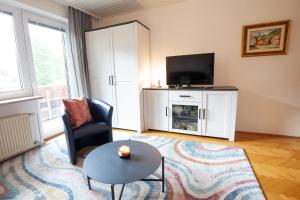 a living room with a tv and a chair and a table at Apartments Kosir in Kranjska Gora
