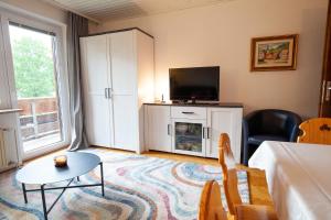 a living room with a tv and a couch and a table at Apartments Kosir in Kranjska Gora