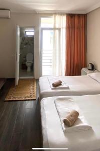 a hotel room with two beds and a bathroom at Guest House Kobuleti on Aghmashenebeli in K'obulet'i