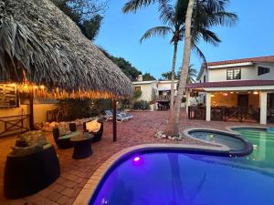 ein Hinterhof mit einem Swimmingpool und einem Haus in der Unterkunft Sylvie Resort Curaçao in Willemstad